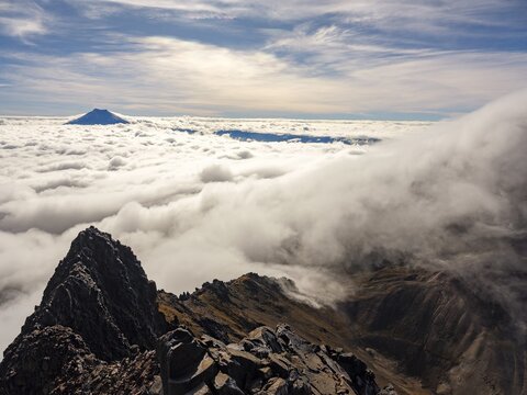 View from the summit of Iliniza North, Cotopaxi volcano in the sea of clouds behind, Pichincha province, Ecuador