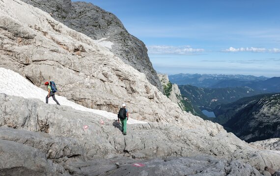 Female mountaineers on a marked route through rocky alpine terrain, from Simonyh&uuml;tte to Adamekh&uuml;tte, with views of Gossausee, Salzkammergut, Upper Austria, Austria in the back
