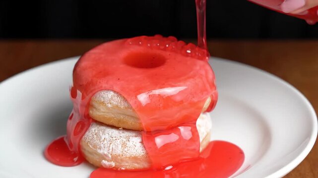 Pink syrup pouring on powdered donuts stacked on white plate with sweet glaze, syrup dripping on dessert, close up food photography, appetizing treat