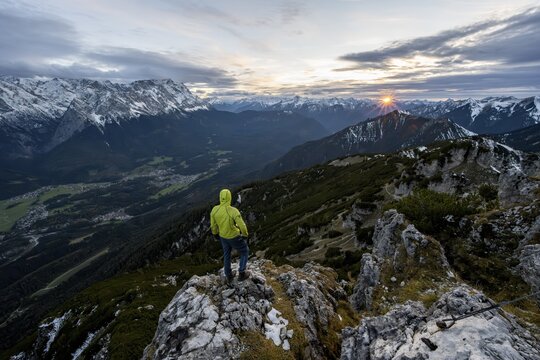 View Mountain panorama with Wetterstein mountains and Zugspitze, at sunset with sun star, mountaineer at the summit of the Kramerspitz, in autumn, Ammergau Alps, in autumn, Bavarian Prealps, Bavaria, Germany