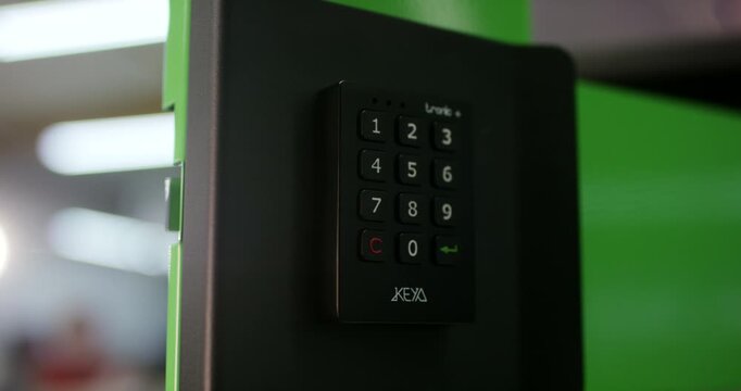 Electronic digital keypad combination lock attached to a green security safe box door panel