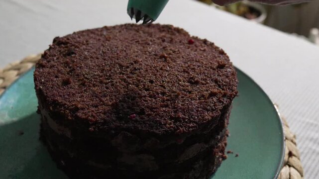 Cake decorating pastry, frosting a chocolate layer cake in the kitchen for a sweet dessert and baking celebration