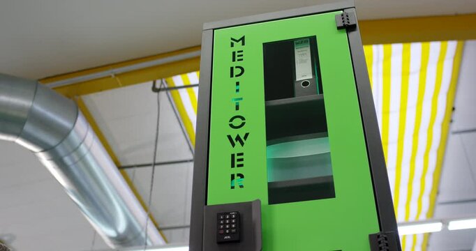 Hand of a person pressing buttons on a digital keypad to open a secure green locker door