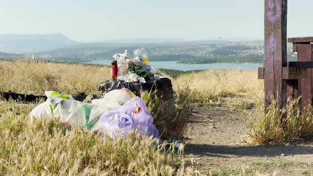 An overflowing trash bin sits in a field, marring the stunning view of Chatyr-Dag Mountain. This sight evokes sadness for nature but highlights the need to protect our beautiful Crimean landscapes.