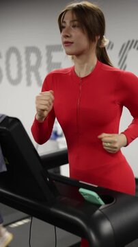 Vertical screen Young woman stays consistent with cardio training on a treadmill improving endurance burning calories and building healthy habits for a stronger body