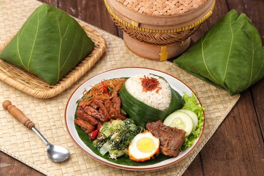 Nasi Berkat Wonogiri, a classic Indonesian ceremonial meal from Wonogiri, Central Java, featuring steamed rice with assorted side dishes such as fried chicken or beef, tempeh, vegetables, sambal, nood