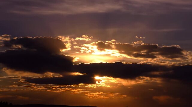 Golden sunlight bursts through dark clouds, creating a dramatic skyscape
