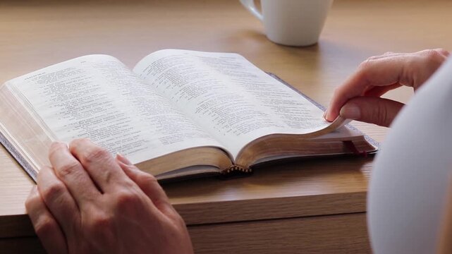A Christian woman is reading from a holy bible. Scripture study concept.