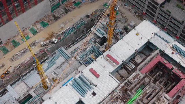Aerial of a large multi building construction project with twin tower cranes