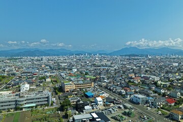 Fototapeta premium Aerial drone photo of Shizuoka city urban sprawl and mountains, Japan