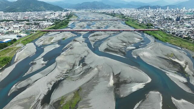 Aerial drone footage of Abekawa River braided channel and Shizuoka cityscape, Japan