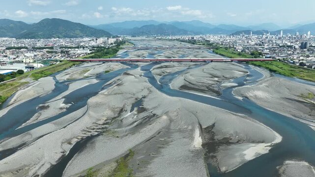 Aerial drone footage of Abekawa River braided channel and Shizuoka cityscape in summer