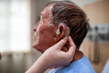 Fototapeta premium Elderly man receiving hearing aid.