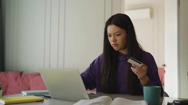 Young Asian woman having online payment problems on a laptop, insufficient funds
