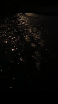 Moonlight reflection shimmering across gentle night sea waves with calm water and natural coastal ambience. Static nighttime seascape with soft wave sounds.