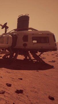 A Mars lander sits on the red surface of Mars. Dusty rocks are scattered around. The sky has a reddish tint as the sun sets in the background. The lander shows signs of advanced technology.