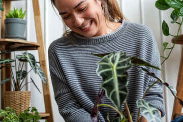 Fototapeta premium Joyful woman tending houseplants indoors.