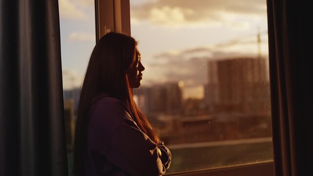 Sad young Korean woman looking out the window, thinking about life problems