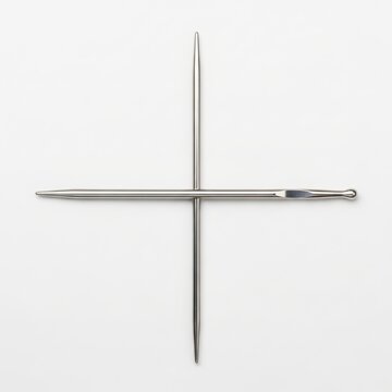 Silver knitting needles crossed in X shape isolated on white background