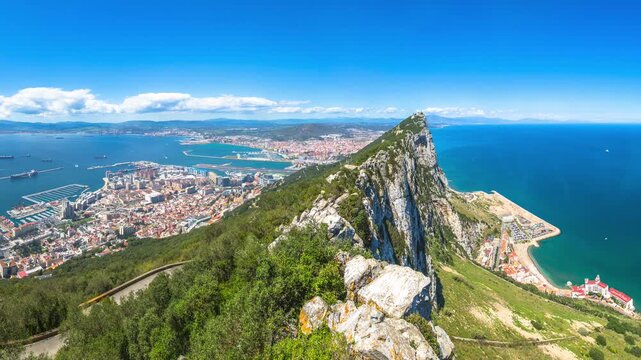 Panorama of top of Gibraltar Rock, in Upper Rock Natural Reserve: on the left Gibraltar town and bay, La Linea town in Spain at the far end, Mediterranean Sea on the right. United Kingdom, Europe.