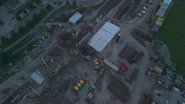 top down drone perspective of a construction project with heavy equipment cranes and excavation work documenting large scale urban development