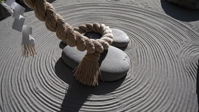 Zen Garden with Raked Sand, Smooth Stones, and Braided Rope.