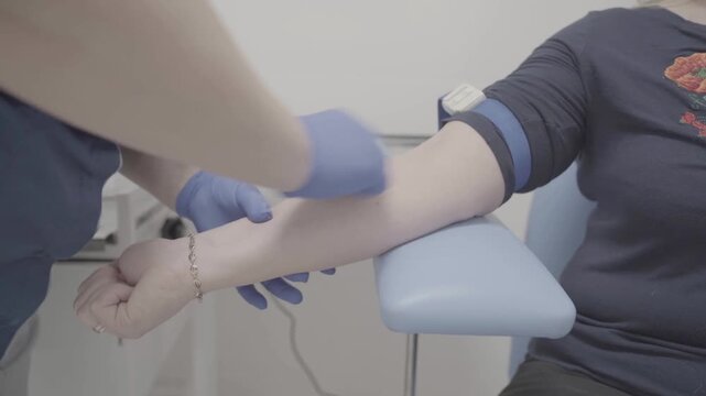 Medical professional applying bandage to patient's arm in clinical setting