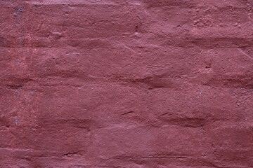 Naklejka premium Textured background of an old weathered brick wall painted in a deep dark maroon color