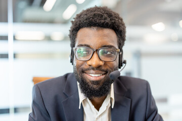 Fototapeta premium Enthusiastic service operator smiling and looking away. Wearing eyeglasses and a headset. Symbolizing friendly support. Effective communication