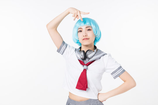 Confident young woman in school uniform cosplay with blue wig and headphones