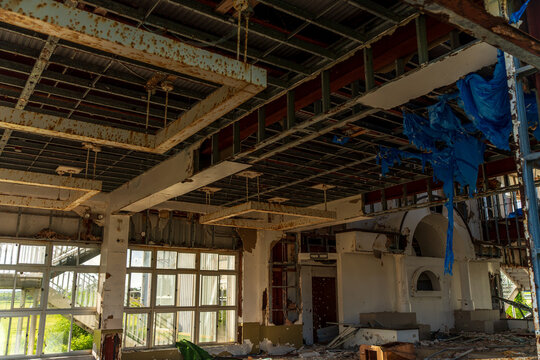 View of the damaged interior of the San Jose Catholic Church with exposed ceiling beams, debris, and blue plastic sheeting in San Jose, Tinian, Northern Mariana Islands.