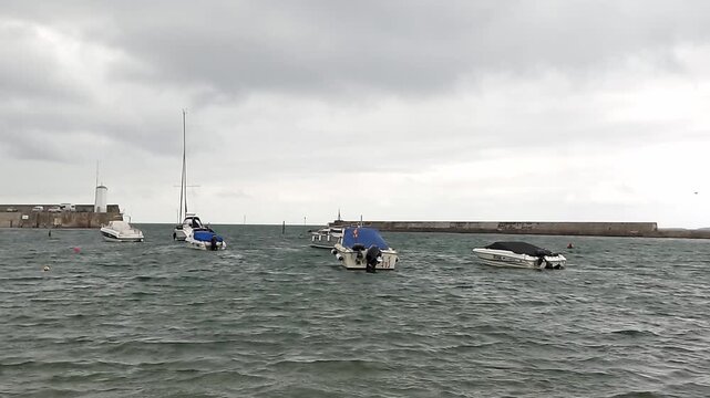 A slow push-in towards boats in Seahouses' outer harbour emphasises the brooding grey skies, dark waters and stormy atmosphere along the rugged Northumberland coastline.