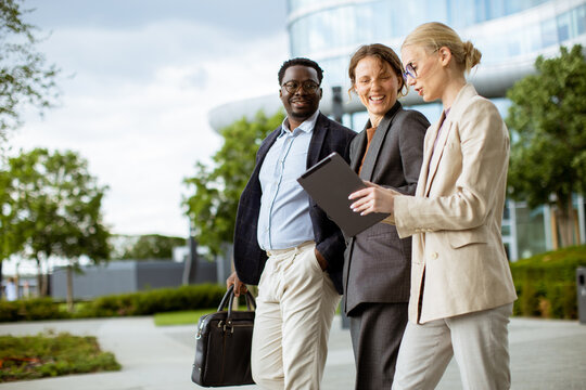 Business team walks outside discussing plans in the city during daytime