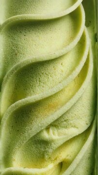 Macro shot of green swirled frozen dessert. Concept of sensory processing and repetitive thoughts. Close-up of pistachio ice cream texture
