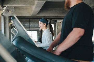 Fototapeta premium Gym treadmill woman man workout fitness exercise running training active indoor gym with smiling woman and bearded man exercising treadmill, cardio workout, healthy lifestyle, modern fitness center