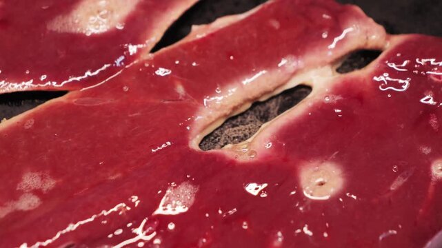 Cooking beef liver steaks in a cast iron skillet. Healthy food concept, cooking at home. . High quality 4k footage