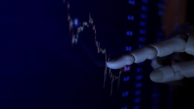 Cinematic close up of humanoid robot hand analyzing economic financial charts on computer monitor. AI business forecasting metaphor, dark office, shallow depth of field, natural dim lighting.