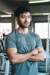 Man gym fitness athlete portrait arm sportswear training exercise confident muscular young man with crossed arms standing in indoor fitness center © chokniti