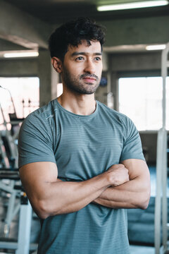 Man gym fitness athlete portrait arm sportswear training exercise confident muscular young man with crossed arms standing in indoor fitness center