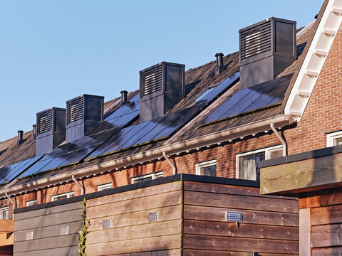 View of the new residential development at the former Veemarkt site featuring rooftop heat pump units and integrated solar panels on brick buildings in Assen, Drenthe, Netherlands.