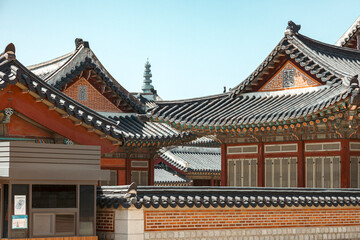 Obraz premium Detailed Vertical View of Traditional Korean Palace Roof with Dancheong Painting and Stone Wall in Seoul