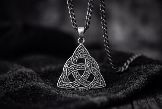 Celtic Trinity Knot Pendant Necklace on Dark Fabric Background