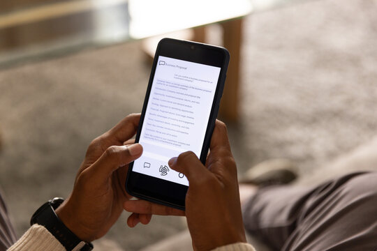 Hands are holding smartphone and scrolling business proposal on carpet near wooden coffee table