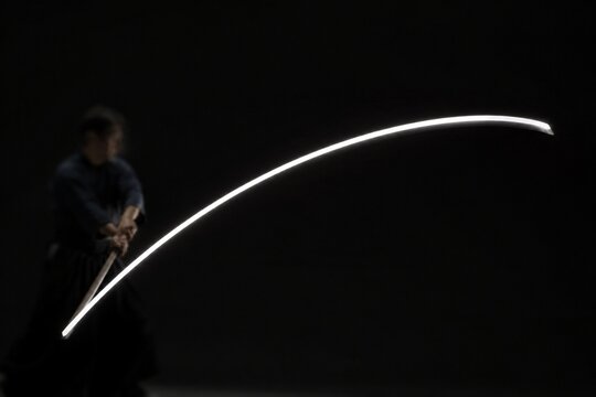 A white arc of light tracing the path of a moving sword.