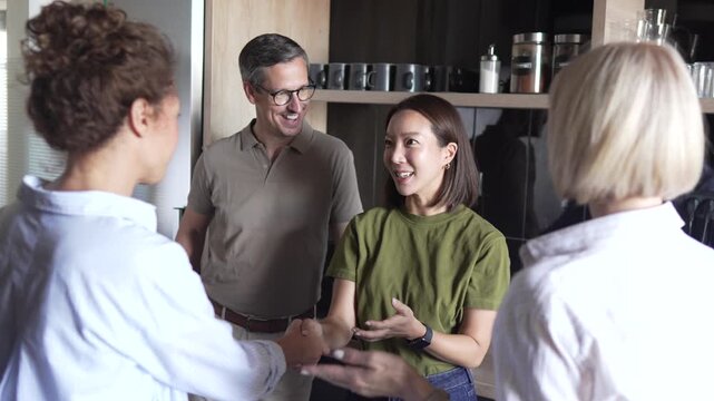 Multicultural business colleagues congratulating asian female coworker