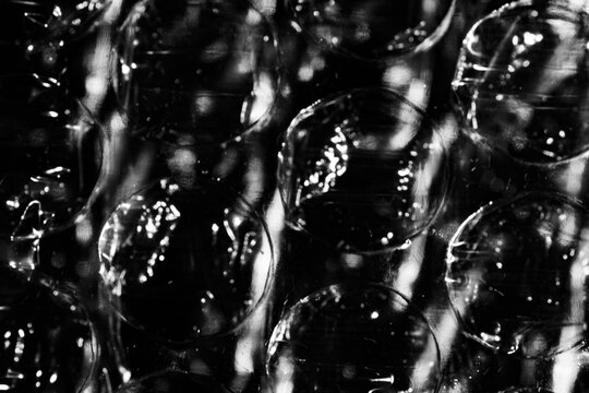 Monochrome macro shot of small-gauge bubble wrap against a black background
