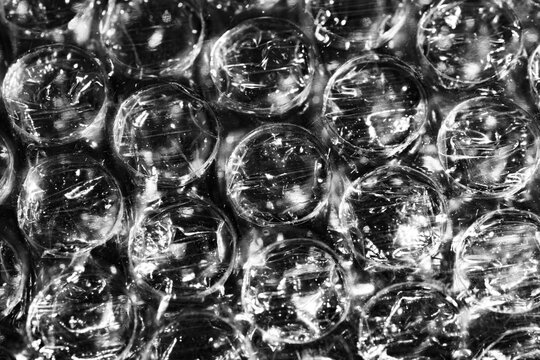 Monochrome macro shot of small-gauge bubble wrap against a black background