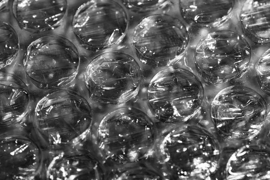Monochrome macro shot of small-gauge bubble wrap against a black background