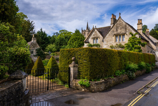 Picturesque village scene featuring St Andrew Church and charming houses in Castle Combe, Wiltshire, England. A popular tourism spot.