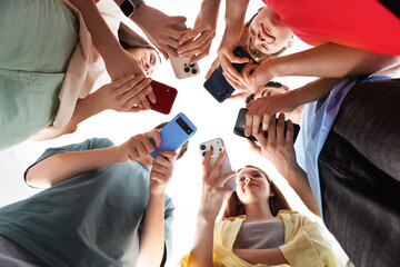 Obraz premium Group of teenagers with different smartphones indoors, bottom view